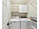 Functional laundry room with washer, dryer, shelving, and storage cabinets for convenience at 9723 Mattforest Cir, Charlotte, NC 28277