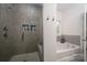 Modern bathroom with tiled shower featuring a built-in bench and recessed shelving, plus soaking tub at 1024 Scotch Meadows Loop # 32, Monroe, NC 28110