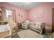 Charming Bedroom featuring pink walls, a crib, soft rug and furniture, and natural lighting at 1024 Scotch Meadows Loop # 32, Monroe, NC 28110