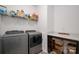 Efficient laundry room with modern washer and dryer, storage shelving, and patterned tile floor at 1024 Scotch Meadows Loop # 32, Monroe, NC 28110