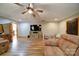 Open living room with wood-look floors, ceiling fan, and ample space for relaxation and play at 122 Roxboro Ct # 286, Mount Gilead, NC 27306
