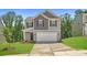 Two-story home featuring a two-car garage, landscaped front yard, and classic architectural details at 134 Dorian Pl, Troutman, NC 28166