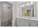Bathroom featuring double sink vanity, large mirror, and tiled shower at 1548 Striped Bass Ln, Clover, SC 29710