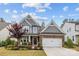 Charming home featuring a stone facade, two-car garage, covered entry, and a manicured front yard at 1548 Striped Bass Ln, Clover, SC 29710