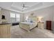 Spacious main bedroom featuring tray ceiling, ceiling fan, and comfortable decor at 1548 Striped Bass Ln, Clover, SC 29710