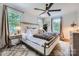 Bright bedroom featuring a large bed with a fur throw, bedside table, and a modern ceiling fan at 2246 Sharon Rd, Charlotte, NC 28207