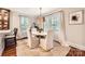 Dining room featuring white upholstered chairs, a round marble table, and a decorative light fixture at 2246 Sharon Rd, Charlotte, NC 28207