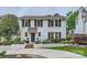 Charming white brick home with a blue door, black shutters, and manicured landscaping at 2246 Sharon Rd, Charlotte, NC 28207