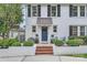 Close up of white brick home with black shutters and well kept front garden area at 2246 Sharon Rd, Charlotte, NC 28207