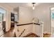 Hallway featuring hardwood floors, white railings, and view into adjacent rooms at 2246 Sharon Rd, Charlotte, NC 28207