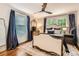 A spacious bedroom has hardwood floors, three windows, and a decorative ceiling fan at 2246 Sharon Rd, Charlotte, NC 28207