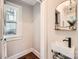 A modern powder room features stylish fixtures, decor, and a bright window, offering a sophisticated touch at 2246 Sharon Rd, Charlotte, NC 28207