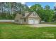 Rear exterior view showing the two-car garage, spacious yard, and manicured landscaping at 2646 N Olivers Cross Rd, Newton, NC 28658