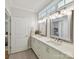 Bright bathroom features a double sink vanity with stone countertops and updated lighting fixtures at 335 Greystone Rd, Charlotte, NC 28209
