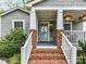 Inviting front porch featuring brick steps, white railing, and a light blue front door with glass panels at 335 Greystone Rd, Charlotte, NC 28209