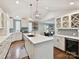 A view of the kitchen with its large island, stainless steel refrigerator and wine cooler, and pendant lighting at 335 Greystone Rd, Charlotte, NC 28209