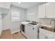 Well-equipped laundry room with modern washer, dryer, sink, and storage cabinets at 335 Greystone Rd, Charlotte, NC 28209
