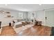 A view of the living room featuring hardwood floors, a large sectional, and natural light from nearby windows at 335 Greystone Rd, Charlotte, NC 28209