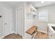 Bright mudroom featuring a built-in bench with storage, hooks, shelves, and wood-look flooring at 335 Greystone Rd, Charlotte, NC 28209