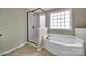 Bathroom showcasing shower with glass door and luxurious bathtub near a natural light window at 4016 Garden Oak Dr, Indian Trail, NC 28079