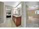 Well-lit bathroom with double vanity, tile floors, and views into the hall and Primary bedroom at 4016 Garden Oak Dr, Indian Trail, NC 28079