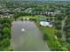 Aerial shot of a community pool, tennis courts, and lake surrounded by lush greenery and neighborhood homes at 4016 Garden Oak Dr, Indian Trail, NC 28079