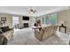 Bright living room features large windows, fireplace, ceiling fan, and comfortable seating at 4016 Garden Oak Dr, Indian Trail, NC 28079