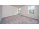 Bright, carpeted bedroom with two windows, offering natural light and serene views at 4225 Summit Woods Dr, Charlotte, NC 28216