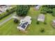Aerial view of a home with solar panels, a metal roof, and a large yard with mature trees, and a detached garage at 543 18Th Nw St, Hickory, NC 28601