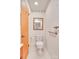 Compact bathroom with white fixtures, wood door, and neutral tones at 6447 E Nc 27 Hwy, Iron Station, NC 28080