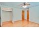Bright bedroom featuring wood floors, closet, and a wooden door at 6447 E Nc 27 Hwy, Iron Station, NC 28080