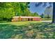 Charming brick ranch-style home with a well-manicured lawn, mature trees, and inviting front entrance at 6447 E Nc 27 Hwy, Iron Station, NC 28080