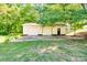 Detached three-car garage with ample parking space and basketball hoop, surrounded by lush greenery at 6447 E Nc 27 Hwy, Iron Station, NC 28080