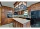 Cozy kitchen featuring wood cabinets, a center island, and a range of appliances for meal preparation at 6447 E Nc 27 Hwy, Iron Station, NC 28080