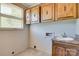 The laundry area has upper cabinets, a sink, and a window, perfect for your laundry needs at 6447 E Nc 27 Hwy, Iron Station, NC 28080