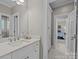 Bright bathroom featuring marble floors, white cabinetry and countertop, and an open view into the bedroom at 6824 N Baltusrol Ln, Charlotte, NC 28210