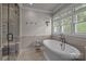 Bright bathroom featuring a modern soaking tub and a glass-enclosed shower at 6824 N Baltusrol Ln, Charlotte, NC 28210