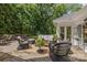 Relax on the outdoor deck with wicker furniture, perfect for enjoying peaceful views of the surrounding trees at 6824 N Baltusrol Ln, Charlotte, NC 28210