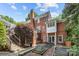 View of the home's backyard, featuring a brick exterior, patio with dining set, and lush landscaping at 6824 N Baltusrol Ln, Charlotte, NC 28210