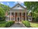 Traditional brick home with a columned entrance, symmetrical design, and a charming front garden with a fountain at 6824 N Baltusrol Ln, Charlotte, NC 28210