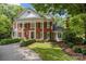 Stately brick residence showcasing a large front yard, classic architecture, and mature trees providing ample shade at 6824 N Baltusrol Ln, Charlotte, NC 28210