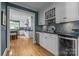 Well-appointed kitchen with white cabinetry, backsplash, wine storage, and a view into additional kitchen area at 6824 N Baltusrol Ln, Charlotte, NC 28210