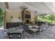 Outdoor living space with a stone fireplace, TV, bar area, and comfortable seating at 6824 N Baltusrol Ln, Charlotte, NC 28210