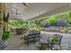 Inviting outdoor living area featuring a stone fireplace, bar, and views of the lush landscaping and pool at 6824 N Baltusrol Ln, Charlotte, NC 28210