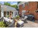 Covered patio featuring outdoor seating, wood decking, a grill and brick exterior at 6824 N Baltusrol Ln, Charlotte, NC 28210