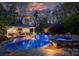 Evening shot of the stunning pool, jacuzzi, and outdoor entertainment area with ambient lighting and lush greenery at 6824 N Baltusrol Ln, Charlotte, NC 28210