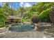 Inviting outdoor pool and jacuzzi area with a pool house, perfect for outdoor relaxation and entertainment at 6824 N Baltusrol Ln, Charlotte, NC 28210
