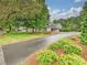 Traditional home with mature landscaping, circular driveway, and covered parking on a sunny day at 7004 Quail Hill Rd, Charlotte, NC 28210