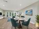 Staged living room featuring modern furniture, light wood floors, and glass doors to the backyard at 7004 Quail Hill Rd, Charlotte, NC 28210
