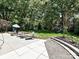 A backyard featuring a patio with furniture, a fire pit, a playhouse, and a lush lawn at 8200 Lansford Rd, Charlotte, NC 28277